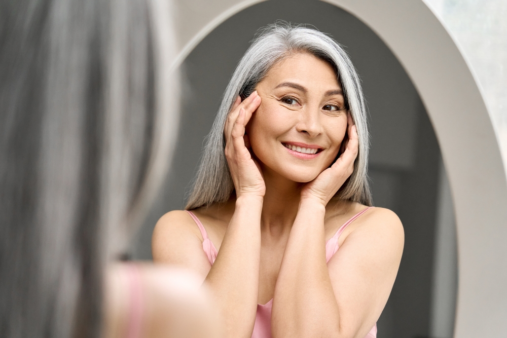 Smiling woman with blonde hair reflecting anti-aging longevity medicine