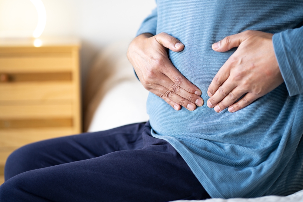 Person holding their abdomen during autoimmune condition evaluation