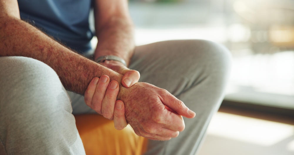 Person holding stiff hands that may benefit from arthritis regenerative therapy