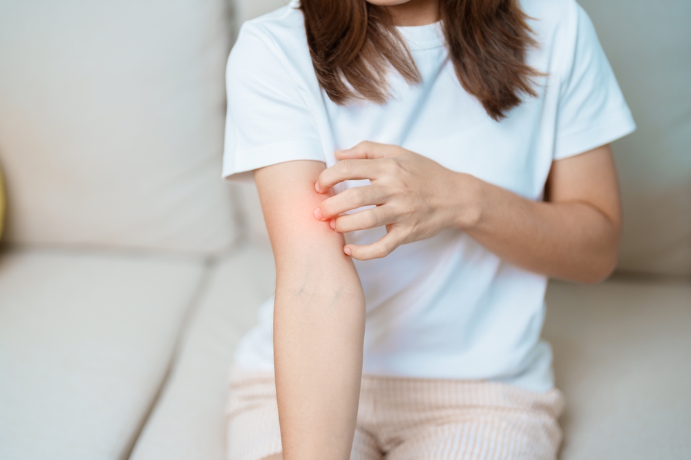 Woman resting her head on her hand showing signs of autoimmune fatigue