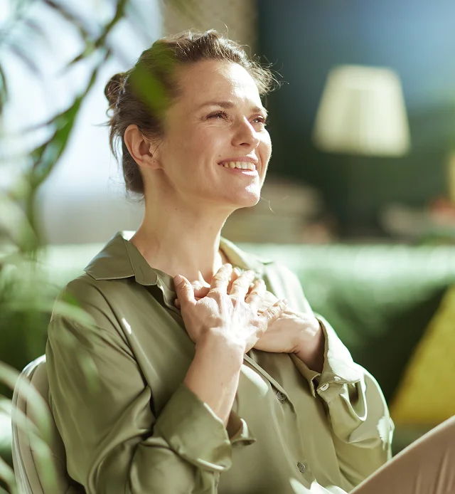 Woman smiling in natural light reflecting physician-supervised wellness