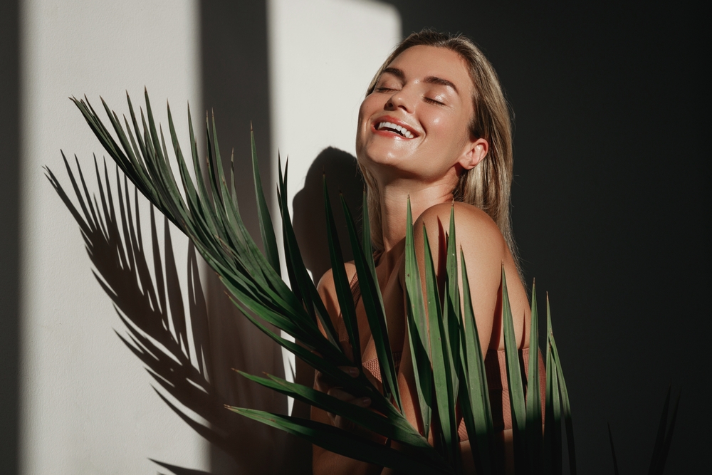 Woman relaxing near tropical foliage in a holistic wellness environment