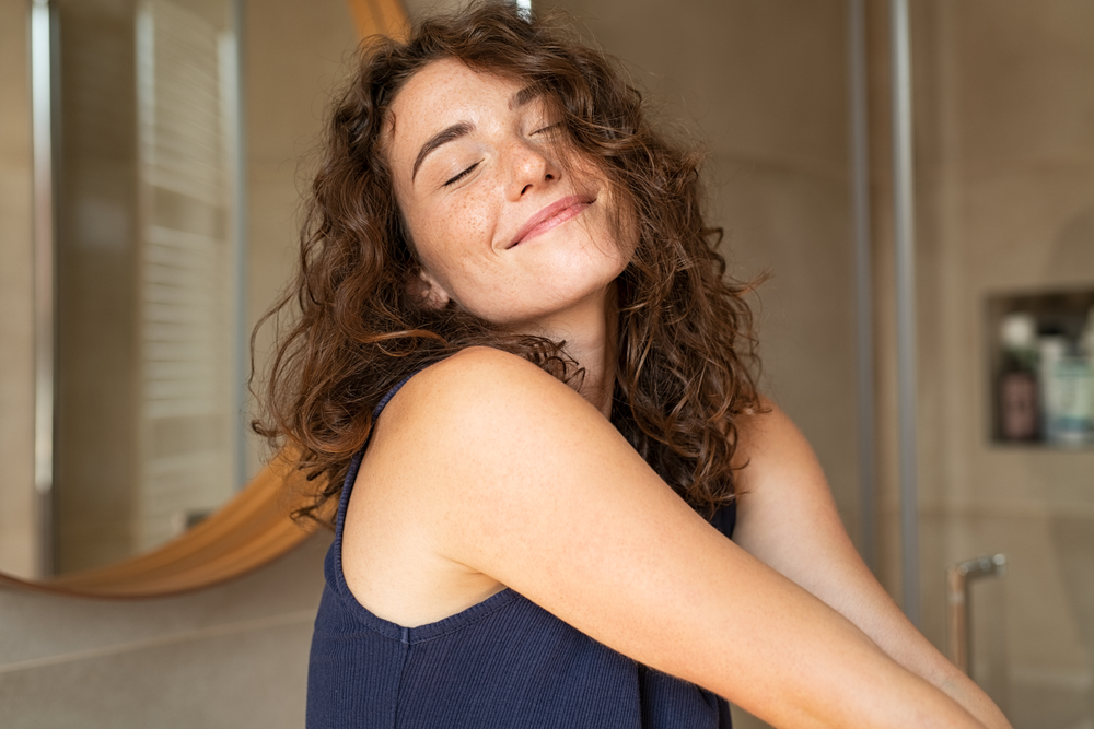 Woman with curly hair smiling after personalized patient-centered care